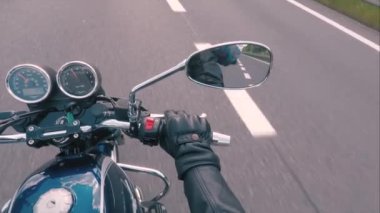 Hareket halindeki bir motosikletin dikiz aynası. Birinci şahıs görüşü. Araç hızı.