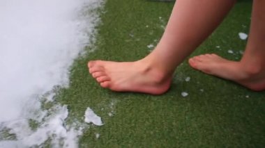 Çocuklar kışın çıplak ayakla kar basar yeşil çimenler yürür beyaz kar basar