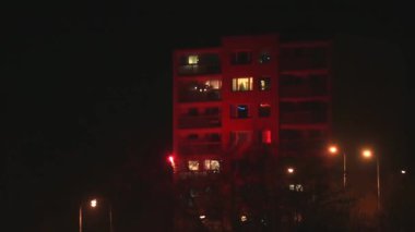 Havai fişeklerin patlaması gece konut binasının ön cephesini aydınlatıyor.