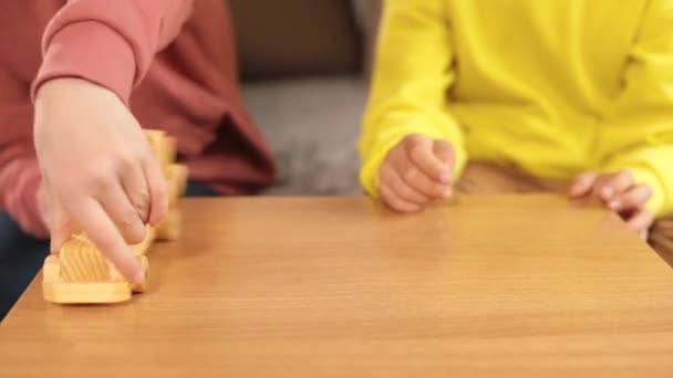 Hände von Jugendlichen spielen mit Holzspielzeug auf dem Tisch — Stockvideo