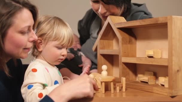 Rodina ženy hraje dcery hračky zaměření pozornost hůl figurka dítě spí paže — Stock video