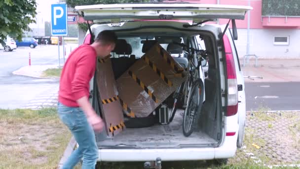 Man takes box out trunk car. Transportation of things by the customer service. — Stock Video