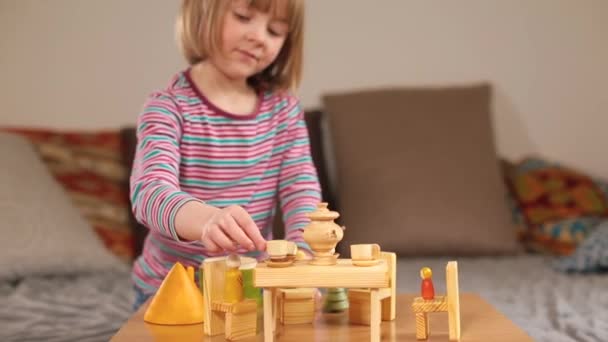 Menina brincando com brinquedos de madeira para crianças feitas de madeira orgânica. Conjunto de chá em miniatura. — Vídeo de Stock