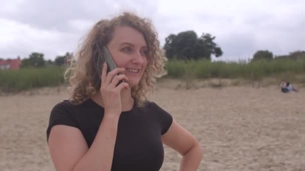Fröhliche Frau telefoniert am Fluss. Sie beendet das Gespräch. — Stockvideo