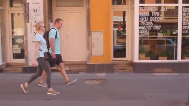 Un homme et une femme descendent la rue. Ils marchent le long du trottoir. — Video