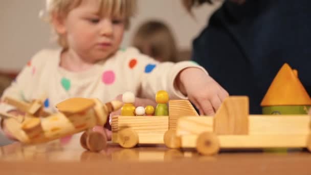 Ξύλινα παιχνίδια στο τραπέζι παιδί ρολόγια κίνηση μαμά χέρι κινείται αντικείμενα. — Αρχείο Βίντεο