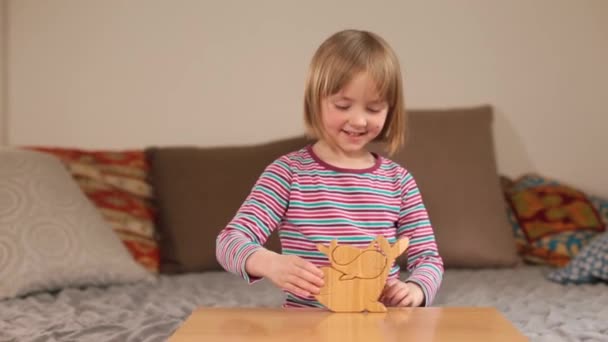 La fille joue avec un jouet en bois sur la table. La joie d'être actif — Video