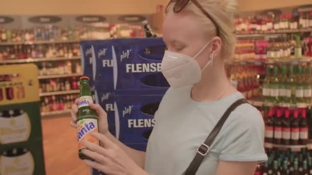 Mulher na mercearia consulta com o marido sobre a escolha de uma bebida — Vídeo de Stock