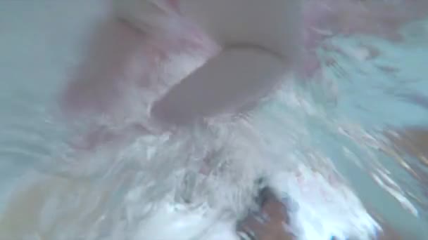 Babyfötter flyter vatten Hon rör sig medan hon lär sig simma Håll balansen ytvatten — Stockvideo
