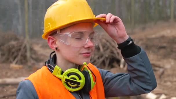 Trabajador de retratos en casco y gafas. Auriculares alrededor del cuello. — Vídeos de Stock