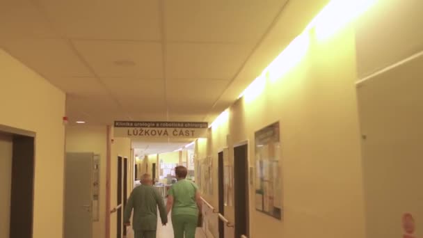 Movimento della telecamera lungo il corridoio in ospedale. Luce vicino al muro, i lavoratori si muovono. — Video Stock