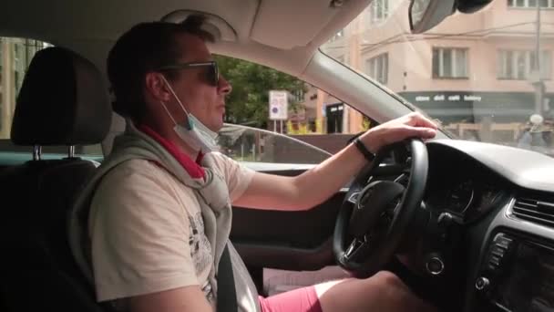 Чоловік водить машину, він дозволяє пішоходам проїхати, показує знак рукою.. — стокове відео