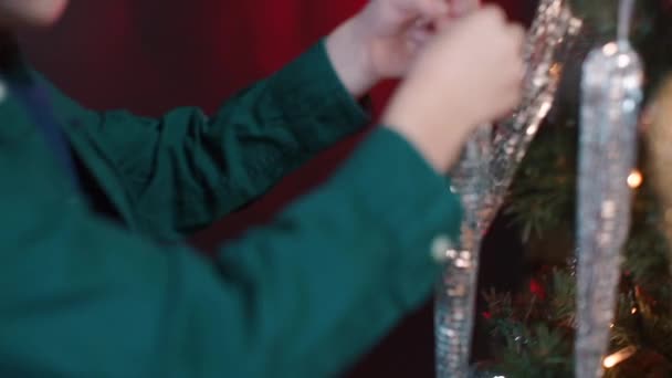 Close-up de crianças mãos penduradas brinquedos de Natal na árvore. — Vídeo de Stock