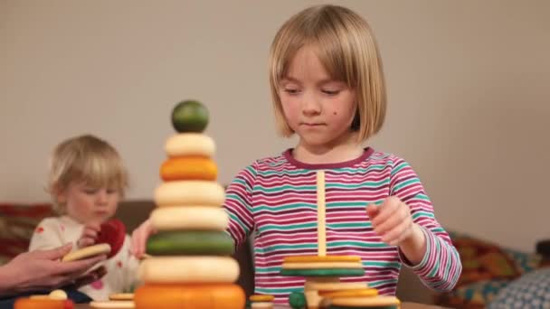 Desenvolvimento de habilidades de raciocínio lógico em crianças. Menina faz uma pirâmide. — Vídeo de Stock
