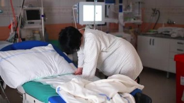 Hamile kadın hastanede yatağın yanında rahatlıyor. Hamileliği oksitosin kullanarak uyarıyor.