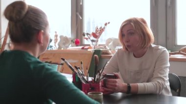 Bir sanat okulu öğretmeni, mesaj öğrencisinin masada oturup ödev hazırladığını söylüyor.