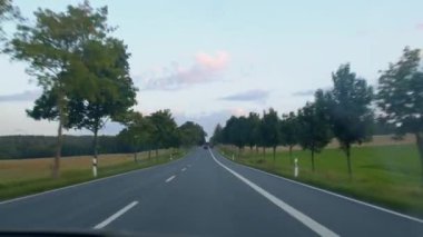 Arabadan yola bak, Sunset. Asfaltta şeritler, şeritleri ayırmak. Gökyüzü.