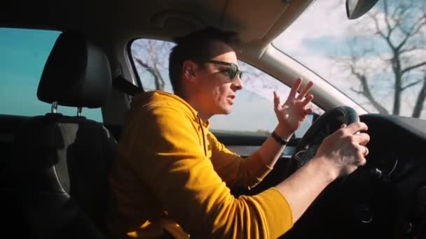 Водитель такси говорит по громкой связи по телефону во время вождения. — стоковое видео
