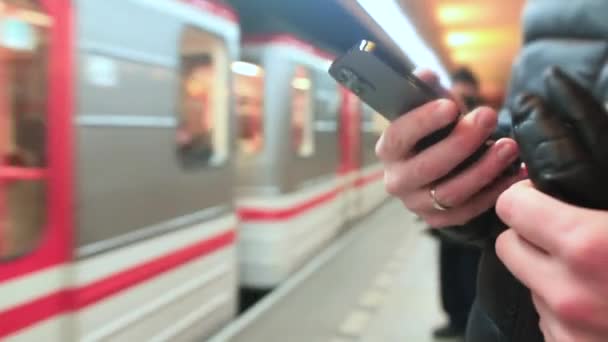 Людина користується мобільним телефоном на залізничній станції. Викупляти електронний квиток перед входом. — стокове відео