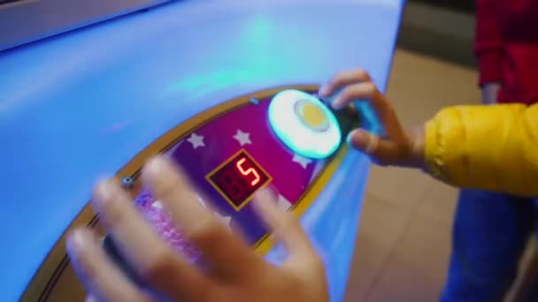 Хлопчики в масках грають на іграшковому крановому автоматі. Ризик наркоманії, попередження азартних ігор. — стокове відео
