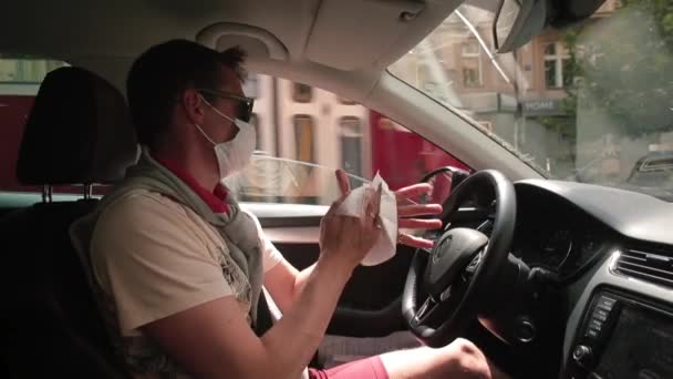 Homem mascarado limpa as mãos com pano úmido no motorista do carro desinfecta as mãos. — Vídeo de Stock
