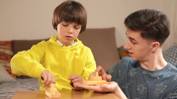 Nauczyciel i dziecko bawią się drewnianymi zabawkami. Rozmawiają, prowadzą dialog pedagogiczny — Wideo stockowe