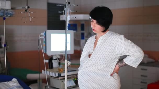 Беременная женщина лежит на кровати в больнице, расслабляясь после схваток. — стоковое видео