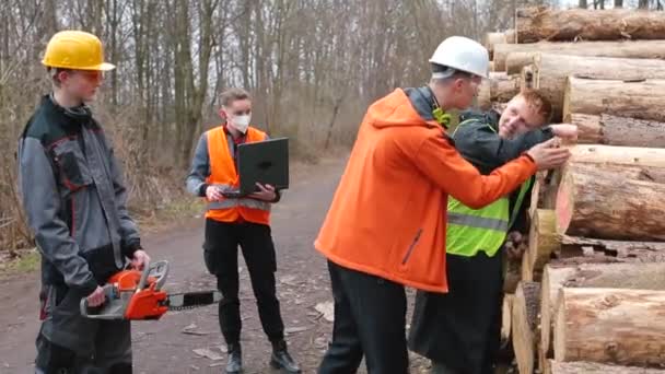 Arbetarna kontrollerar träkvaliteten i avverkningen. Kommunikationschef anställd. — Stockvideo