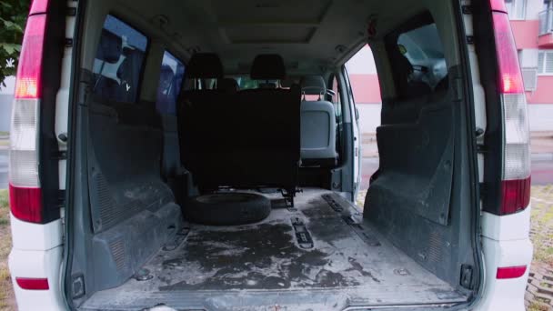Minivan auto s otevřeným kufrem opustí parkoviště v blízkosti domu — Stock video