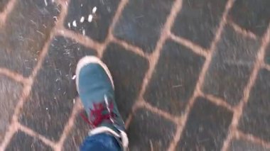 Kışlık ayakkabılar kaldırıma basar. İnsan hareketi, gözlerden görüntü