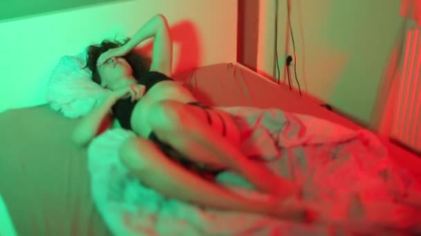 Una donna a letto trova una posizione comoda durante lo stress. Movimenti riflessivi. — Video Stock