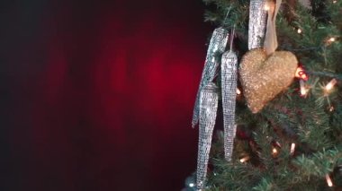 Kırmızı şapkalı çocuk ağaca Noel oyuncağı asıyor. Noel ağacı süslemesi.
