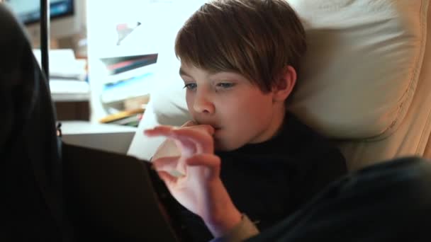 O adolescente usa um comprimido à noite no quarto. Experiência interna assistindo vídeo. — Vídeo de Stock