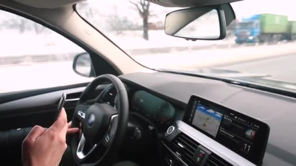 Движение автомобиля по автомагистрали водитель использует телефон в руках — стоковое видео