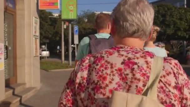 Ryggsäck man flyttar med kvinna längs stadens gata. Glasögon. — Stockvideo