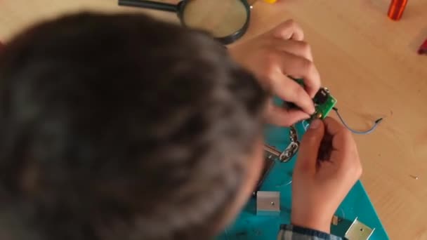 トップ表示の少年は、電気機器の詳細マイクロ回路を作る. — ストック動画
