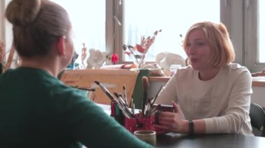 Psikolog psikoterapi sırasında hastayla konuşuyor. Sanat terapisi dolabı.