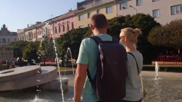 Paar Backs in der Nähe der Brunnenstadt. Freizeitaktivitäten Stadtpark, Entspannung Psyche — Stockvideo