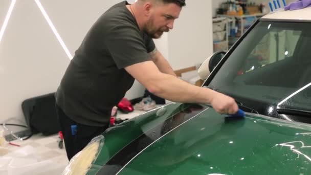 As mãos do reparo põem o veículo da laca da pintura da proteção polimérica do carro da fita vinil — Vídeo de Stock