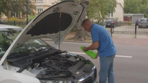 Derramando fluido da máquina de lavar no tanque do capô do carro. Veículo a motor de manutenção programada. — Vídeo de Stock