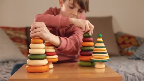Adolescent se déplace mains jouets pyramide en bois sur la table. Réalisation créative, — Video
