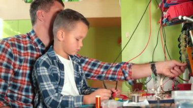 Baba ve oğlu elektrik testi yapıyor. Verileri kontrol etmek için kabloları bağlıyorlar.. 