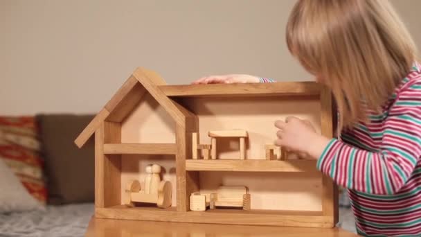 Bambino indipendente giocare casa di legno Con le mani mette oggetti associazioni casa — Video Stock