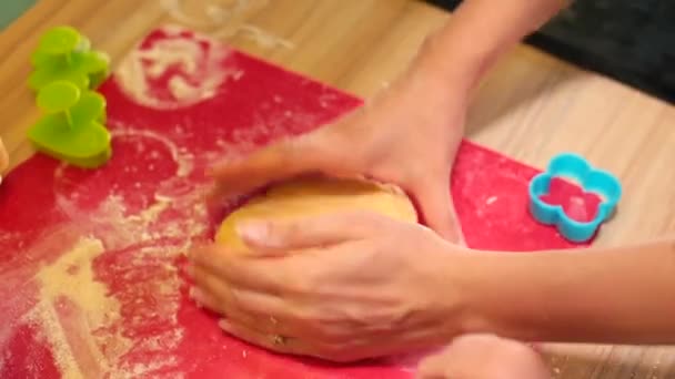 Las manos de los niños extienden la masa con un rodillo. Preparación para la fabricación de alimentos — Vídeo de stock