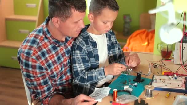 Homeschooling papá padre habla acerca de la técnica de hacer un tablero eléctrico — Vídeos de Stock