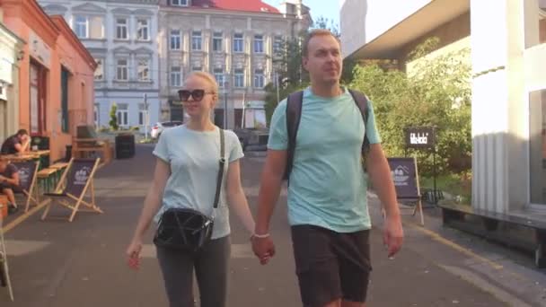 Hombre y mujer tomados de la mano en la calle de la ciudad en la fecha. El afecto en la vida juntos — Vídeo de stock