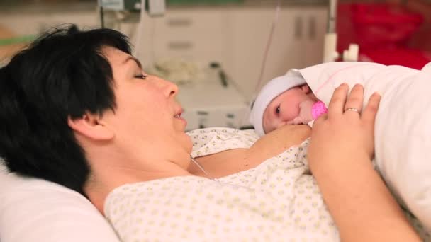 一位年轻的母亲正在哺乳婴儿。新生儿的自然喂养. — 图库视频影像
