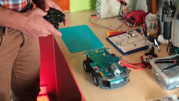Mouvements de voitures jouets sur la table. Mains utilise le dispositif de contrôle du contrôleur. — Video