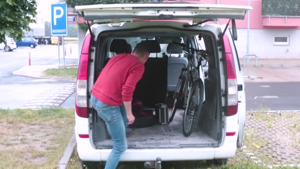 El cargador toma objetos y cosas del maletero del coche. — Vídeos de Stock