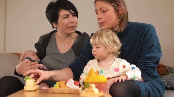 两个伙伴家庭与有玩具的孩子一起玩桌球动机独立游戏 — 图库视频影像